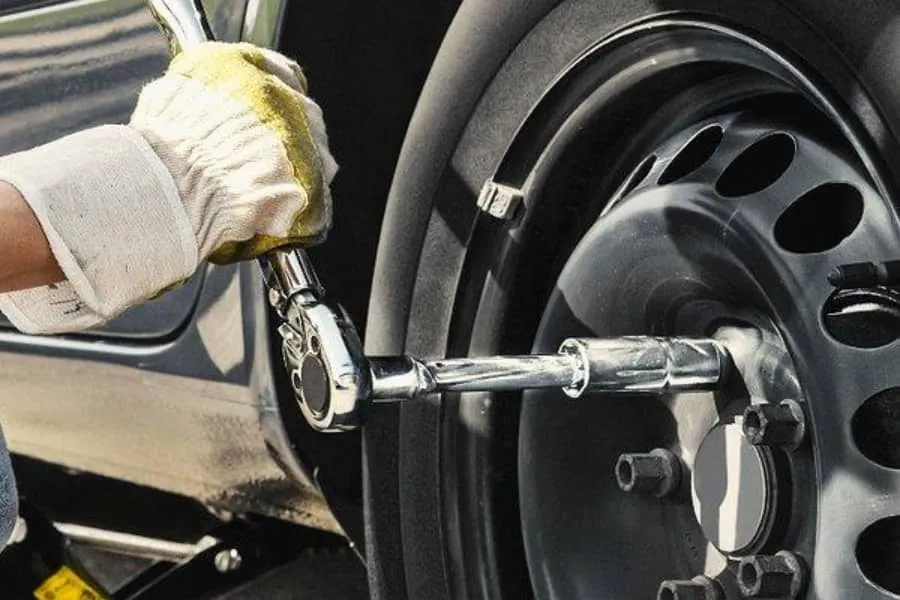 Mecânico verificando pneu e porcas da roda